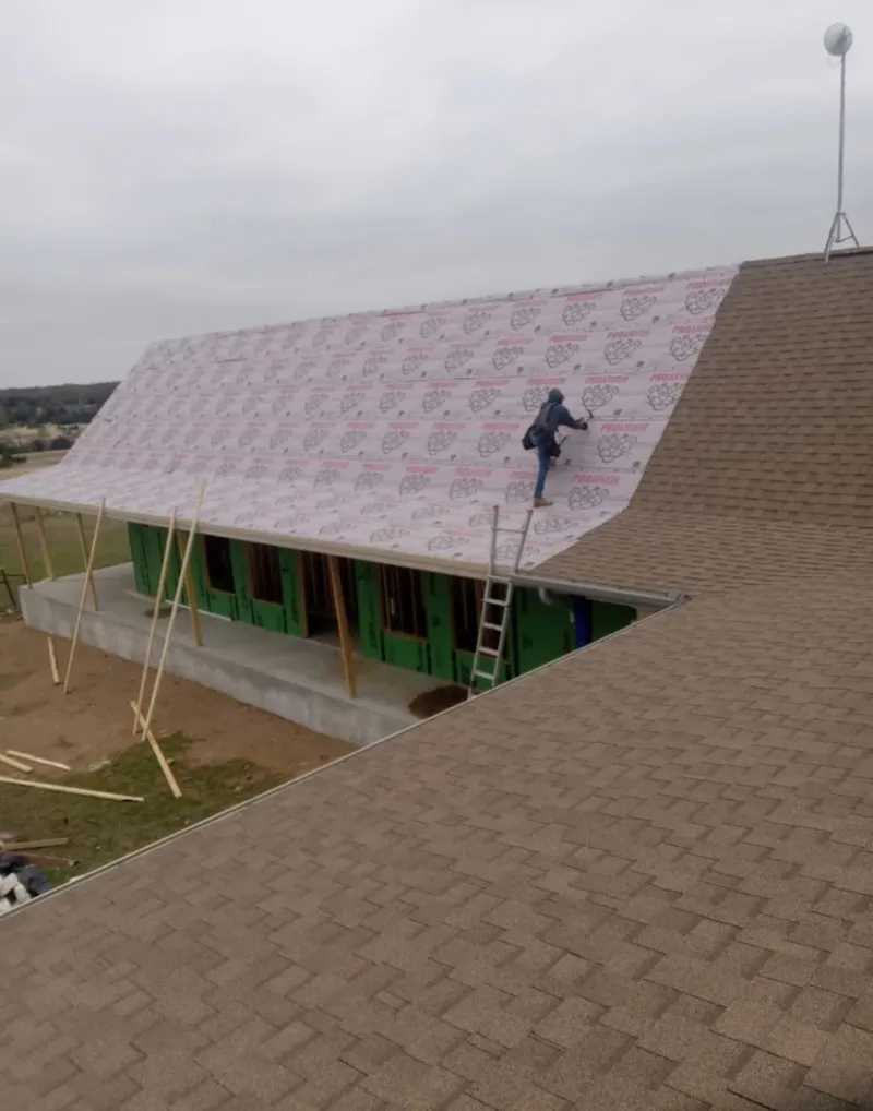 Worker preparing underlayment for a metal roof installation in Staunton